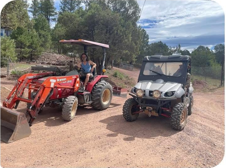 Road grader working on gravel road in summer
